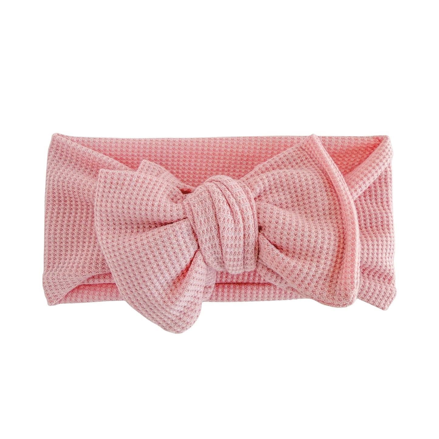 Oversized bow baby headband in dusty pink, crafted from waffle knit fabric, displayed on a white background