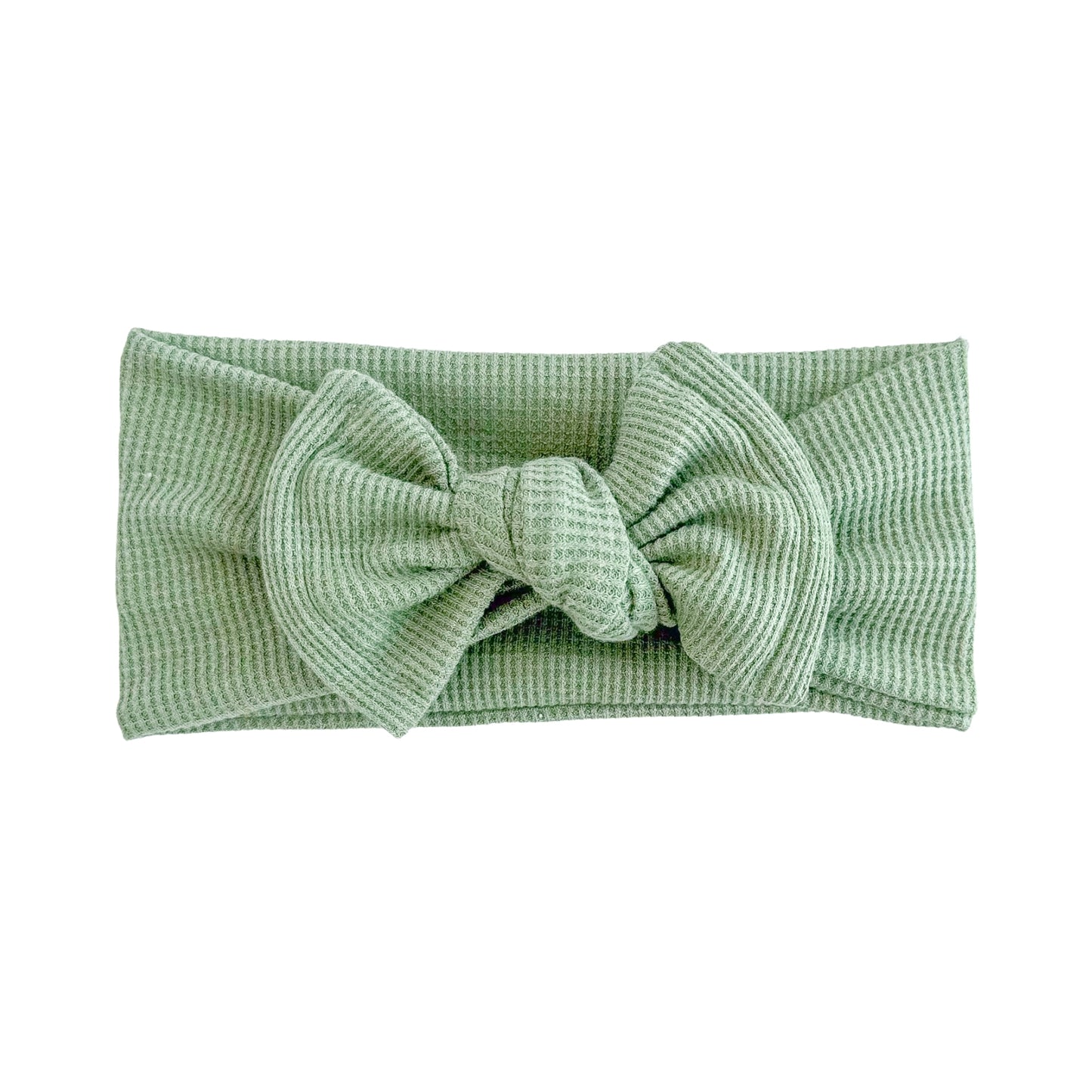 Top knot baby headband in green, crafted from waffle knit fabric, displayed on a white background