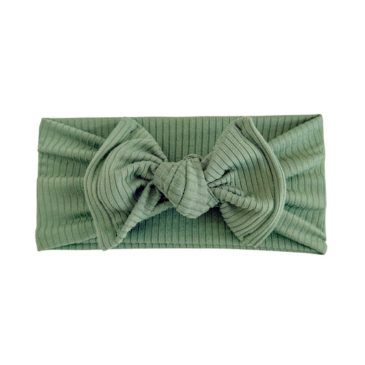 Oversized bow baby headband in hunter green, crafted from ribbed knit fabric, displayed on a white background
