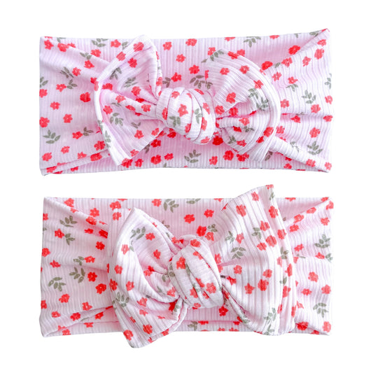 Baby girl headbands in top knot and oversized bow styles in light pink with dainty coral floral pattern, made from ribbed knit fabric