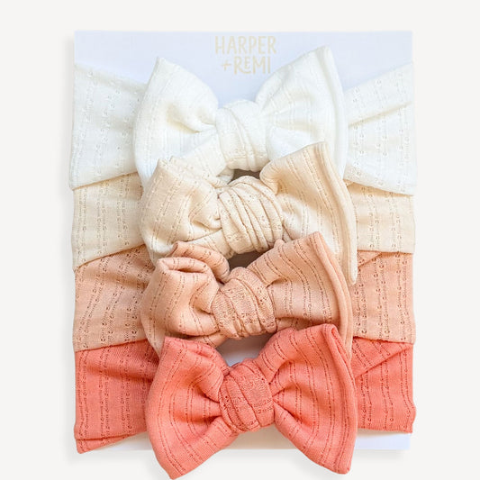 Set of colorful fabric bows held by a hand on a wooden surface