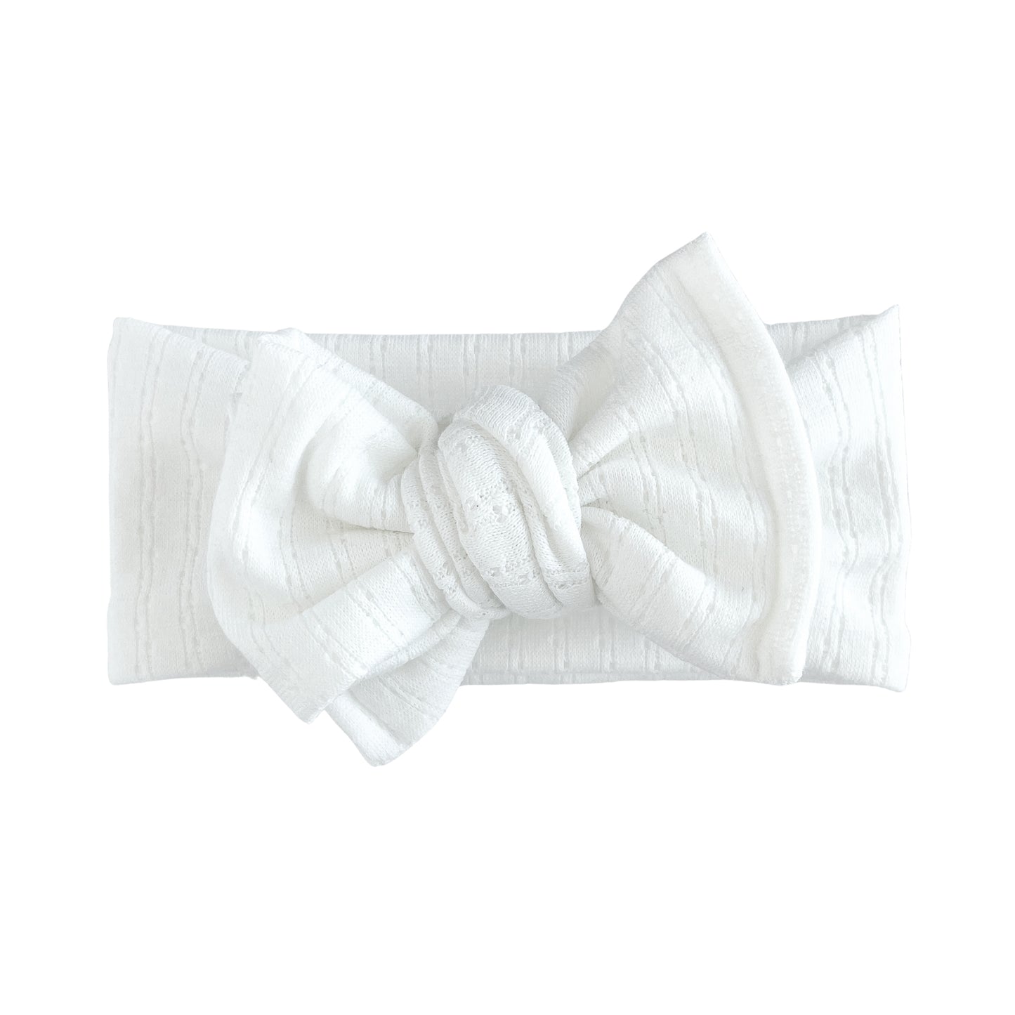 Oversized bow baby headband in white, crafted from pointelle knit fabric, displayed on a white background