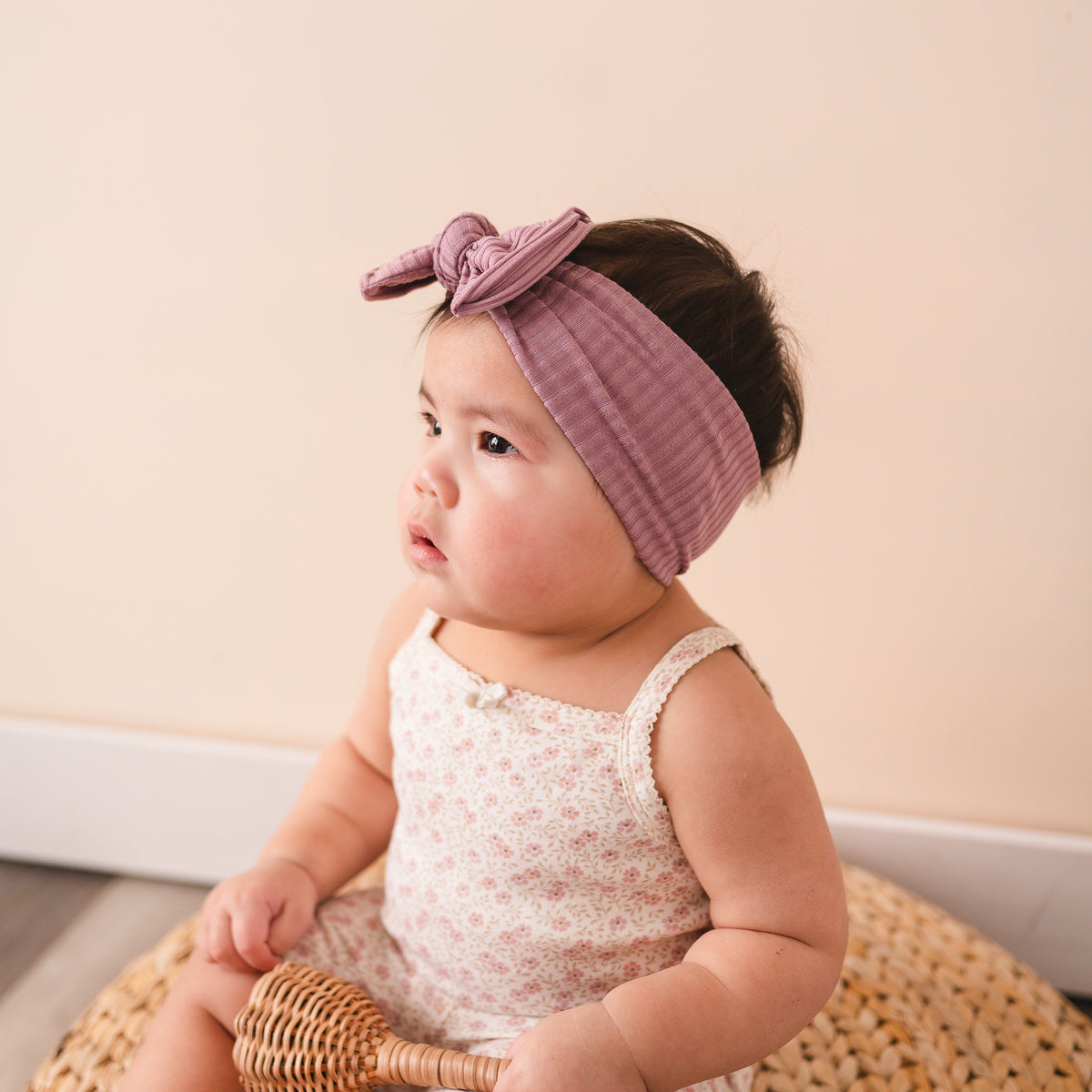 Oversized bow baby headband in purple, crafted from ribbed knit fabric, displayed on a white background