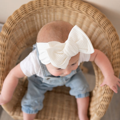 Top knot baby headband in white, crafted from cotton ribbed knit fabric, displayed on a white background