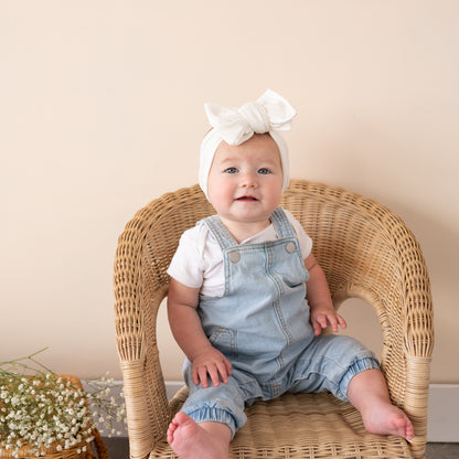 Oversized bow baby headband in white, crafted from cotton ribbed knit fabric, displayed on a white background
