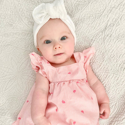 Top knot baby headband in white, crafted from ribbed knit fabric, displayed on a white background