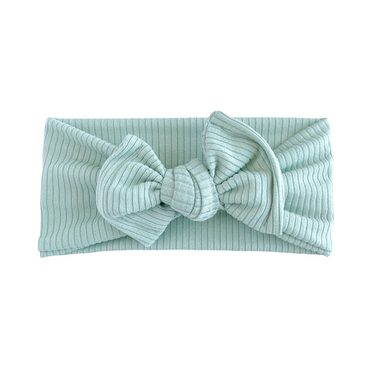 Oversized bow baby headband in aqua, crafted from ribbed knit fabric, displayed on a white background