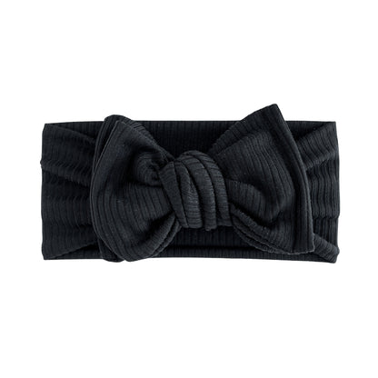 Top knot baby headband in black, crafted from ribbed knit fabric, displayed on a white background