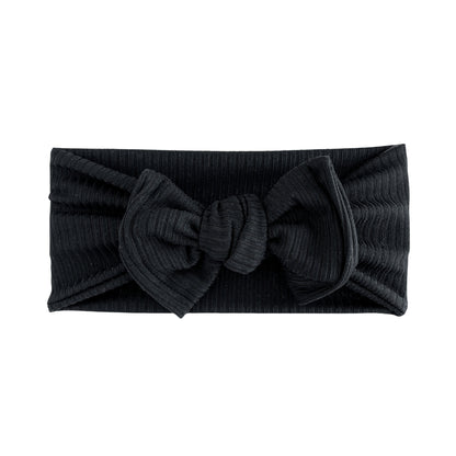 Oversized bow baby headband in black, crafted from ribbed knit fabric, displayed on a white background