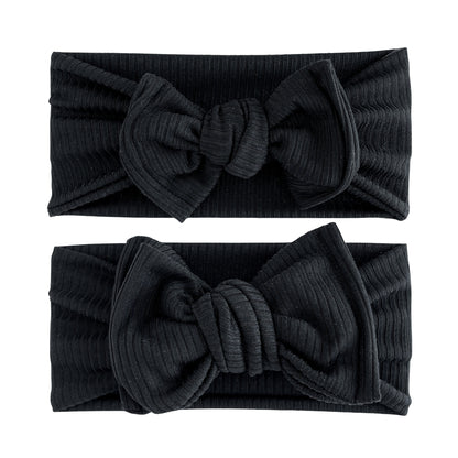 Baby girl headbands in top knot and oversized bow styles in black, made from ribbed knit fabric