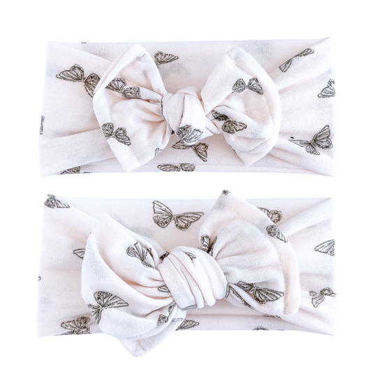 Two blush headbands with butterfly patterns on a white background