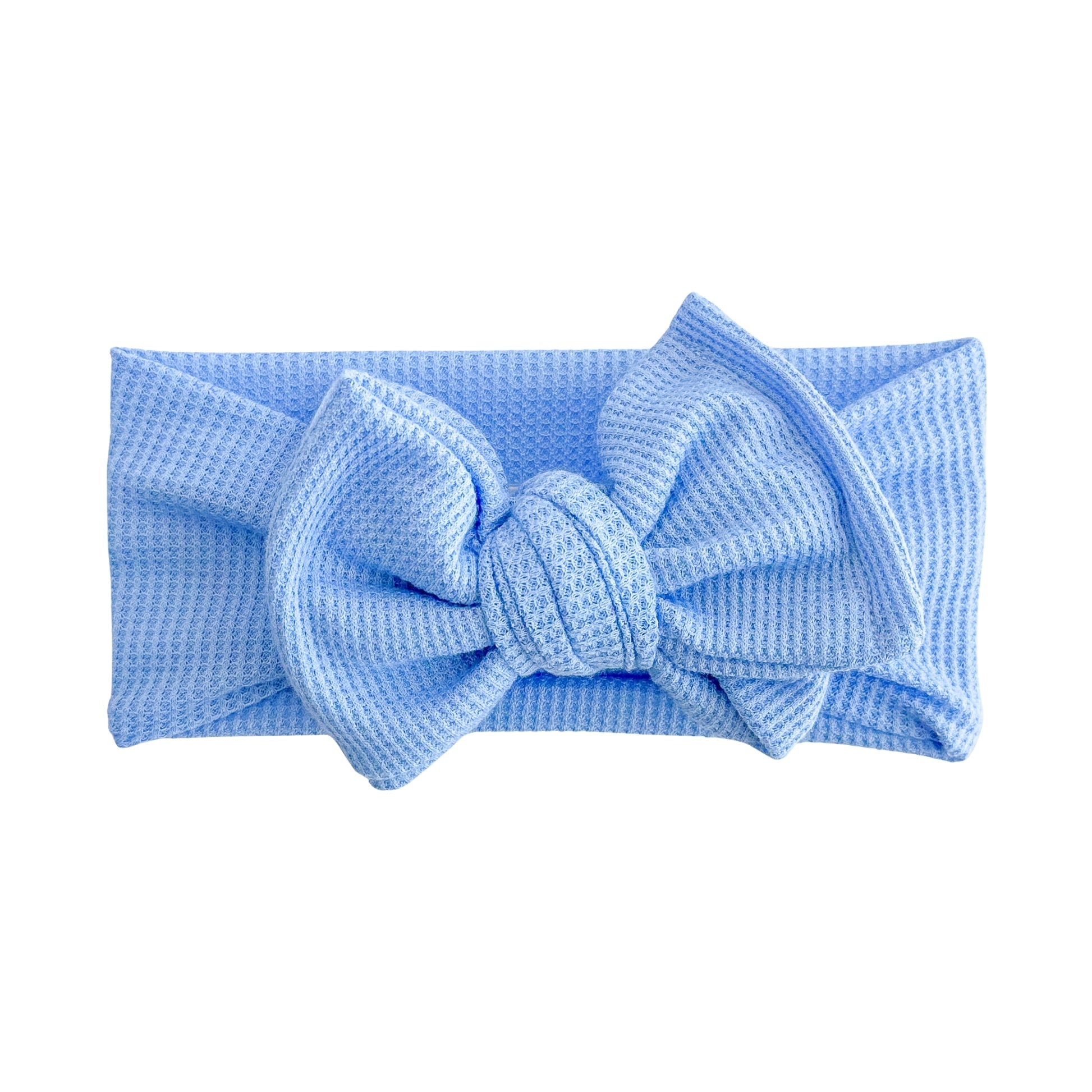 Oversized bow baby headband in bright blue, crafted from waffle knit fabric, displayed on a white background