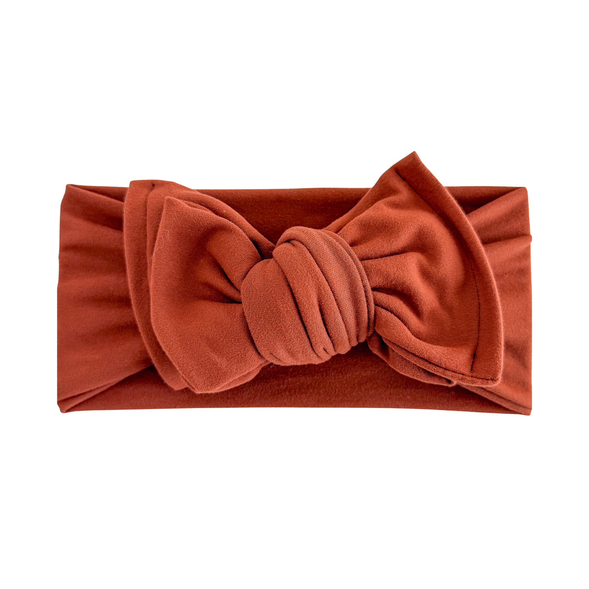 Oversized bow baby headband in spice (dark orange), crafted from double brushed knit fabric, displayed on a white background