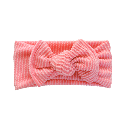 Bright pink baby headband with wavy ribbed texture.