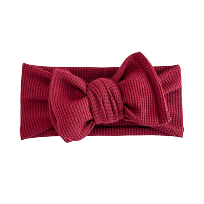 Oversized bow baby headband in burgundy, crafted from waffle knit fabric, displayed on a white background