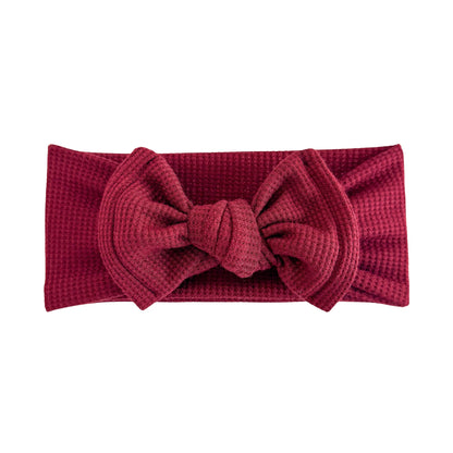 Top knot baby headband in burgundy red, crafted from waffle knit fabric, displayed on a white background