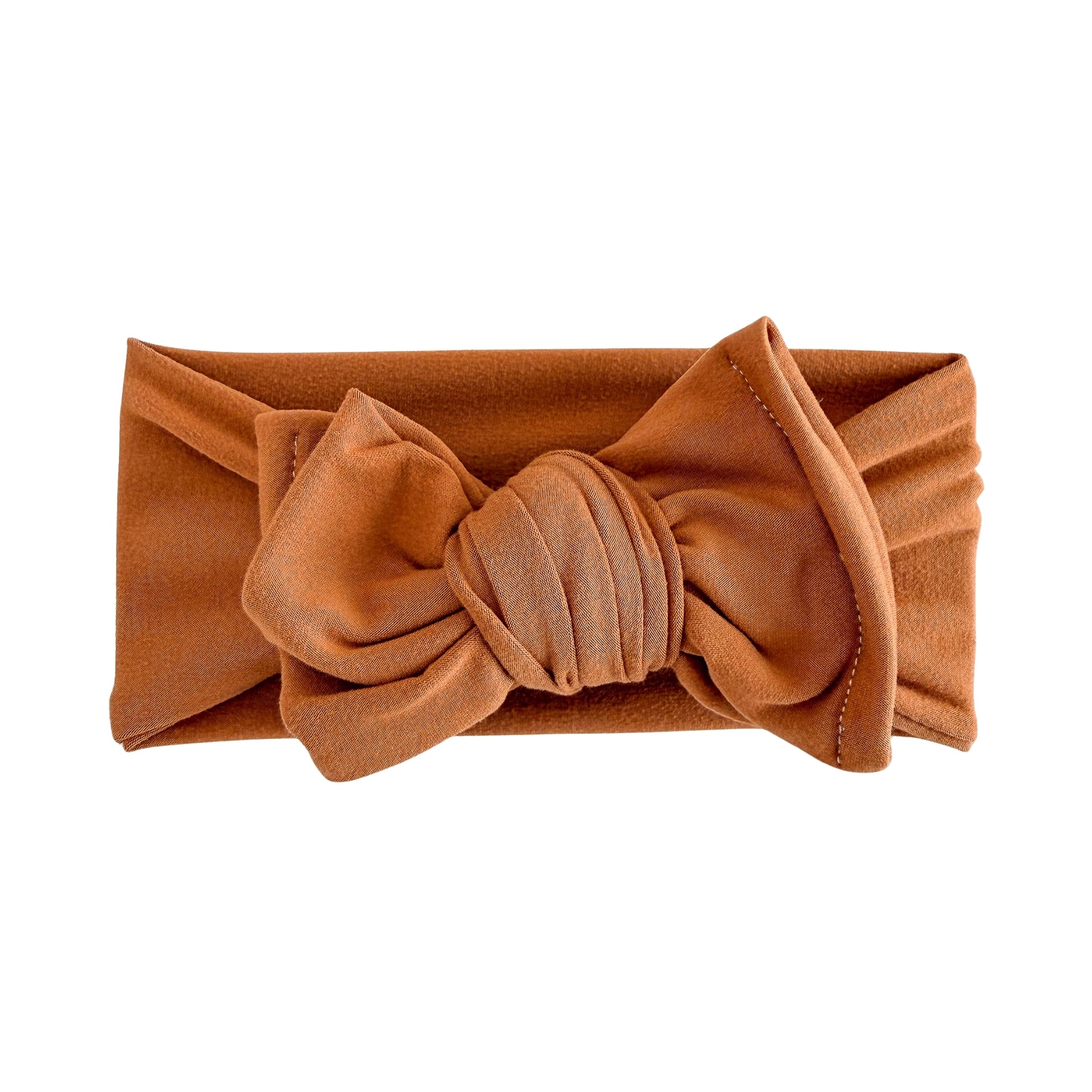 Oversized bow baby headband in burnt orange, crafted from double brushed knit fabric, displayed on a white background
