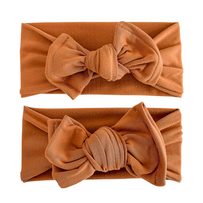 Baby girl headbands in top knot (top) and oversized bow (bottom) styles in burnt orange, made from double brushed knit fabric