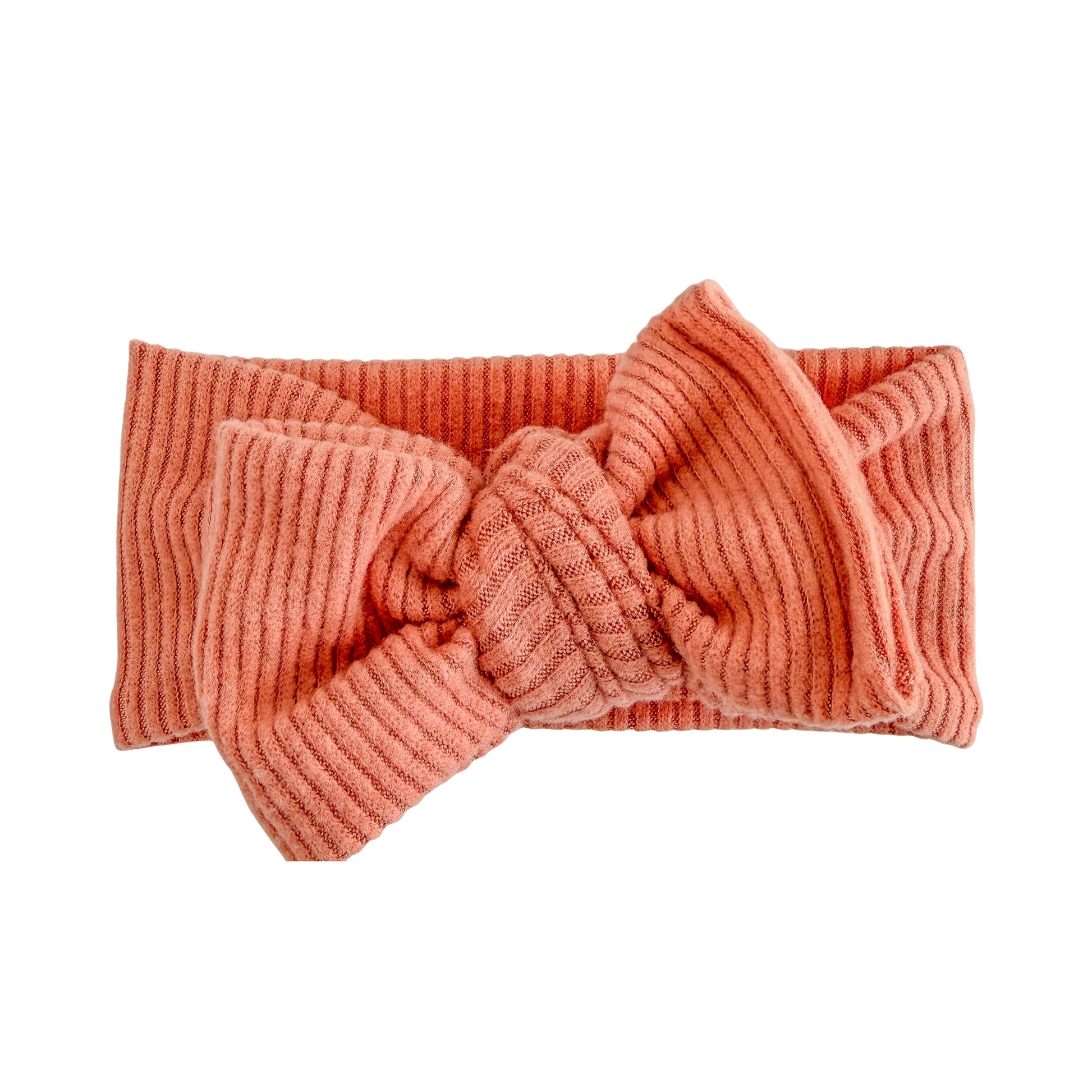 Oversized bow baby headband in coral, crafted from fuzzy brushed ribbed knit fabric, displayed on a white background