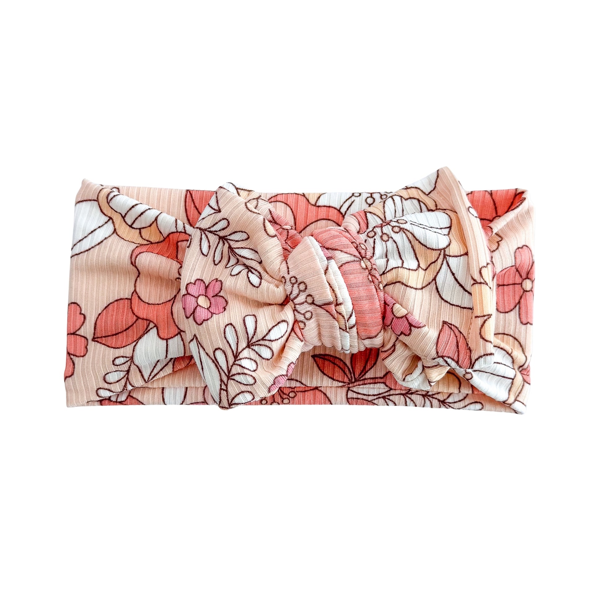 Oversized bow baby headband in coral large floral print, crafted from ribbed knit fabric, displayed on a white background