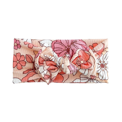 Coral floral ribbed top knot headband on a white background.