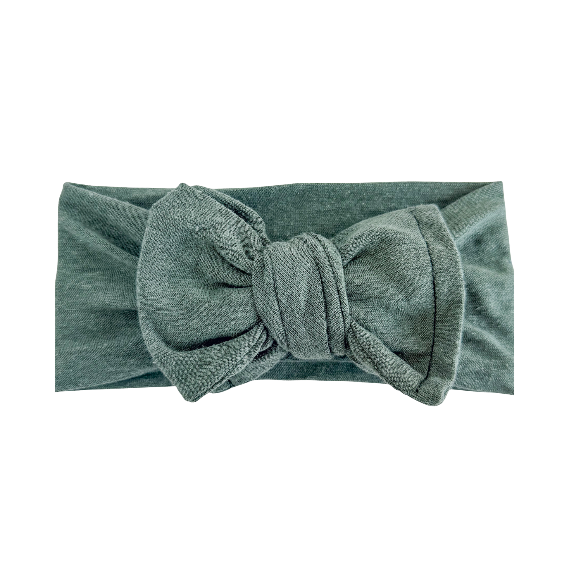 Oversized bow baby headband in lichen green, crafted from cotton jersey knit fabric, displayed on a white background