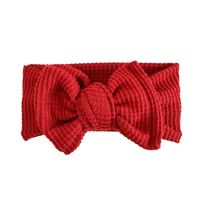 Oversized bow baby headband in dark red, crafted from brushed waffle knit fabric, displayed on a white background