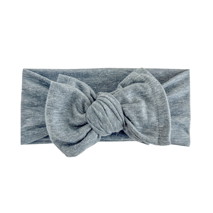 Oversized bow baby headband in blue grey, crafted from cotton jersey knit fabric, displayed on a white background