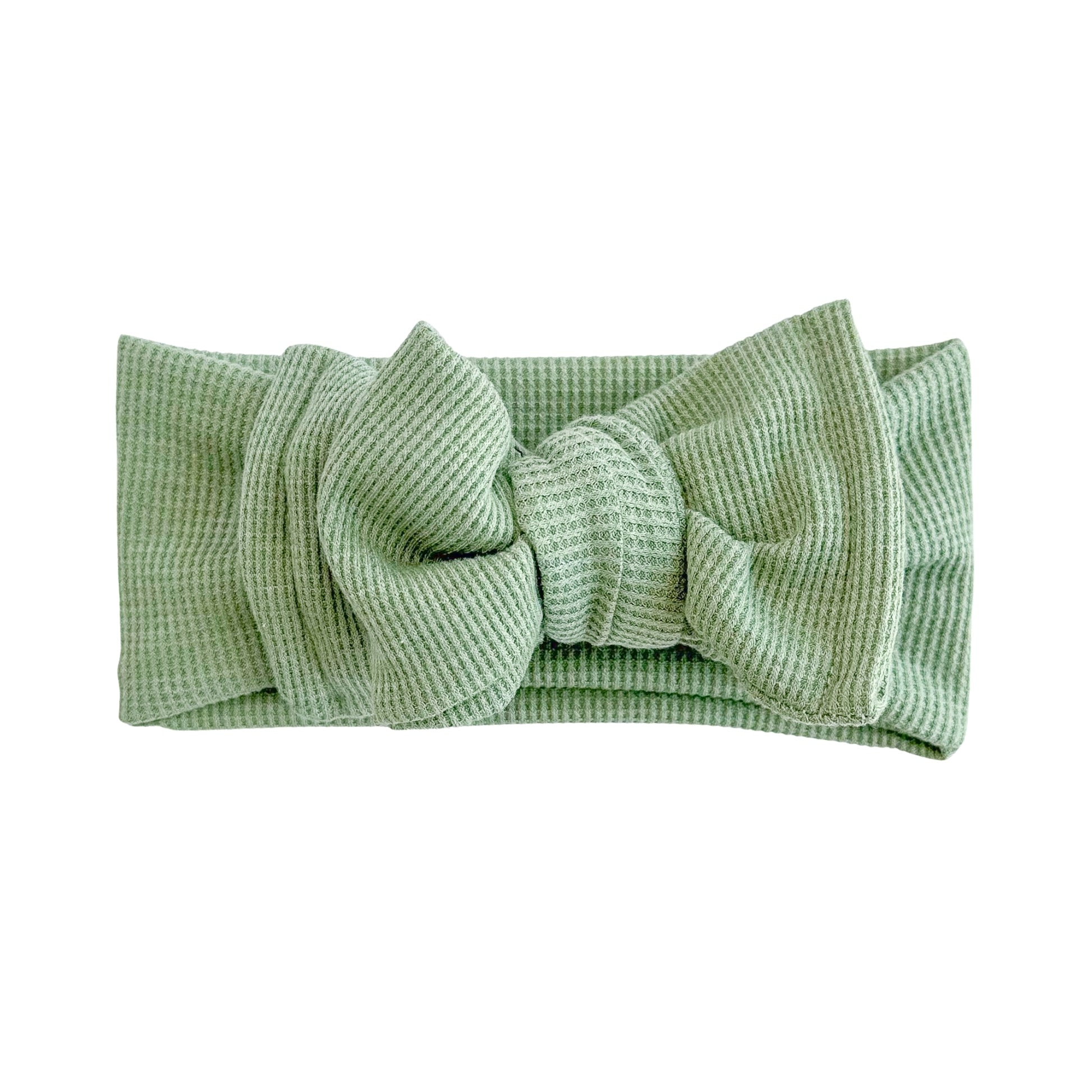 Oversized bow baby headband in green, crafted from waffle knit fabric, displayed on a white background