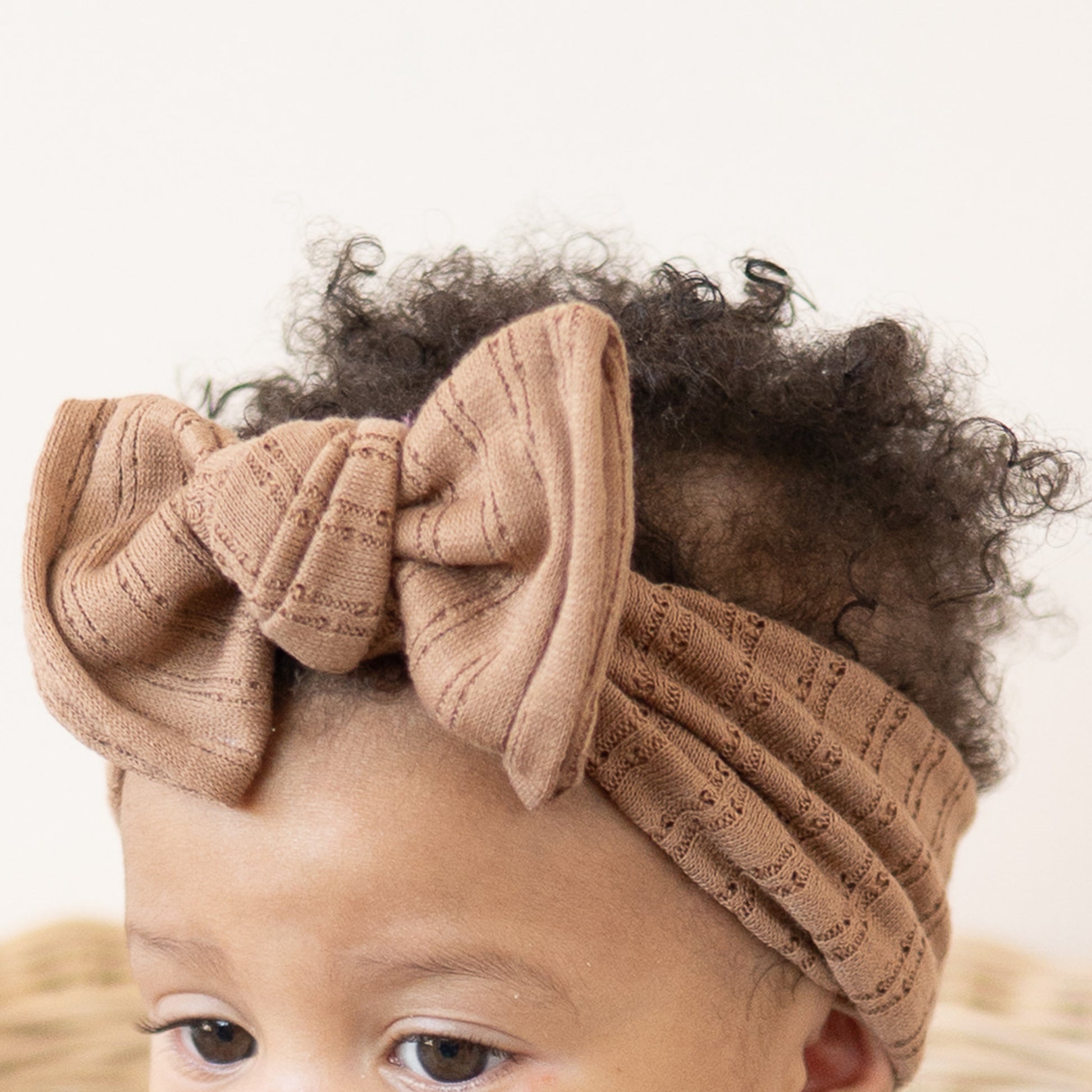Mocha brown pointelle fabric baby headband close up texture.