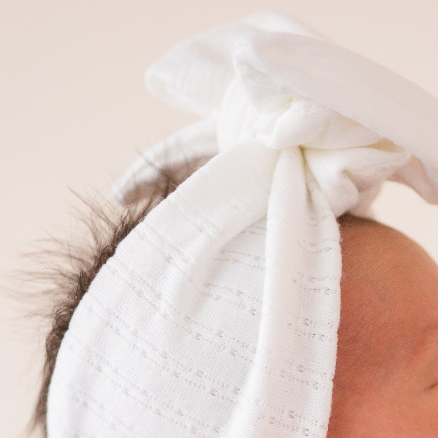 White pointelle fabric baby headband close up texture.