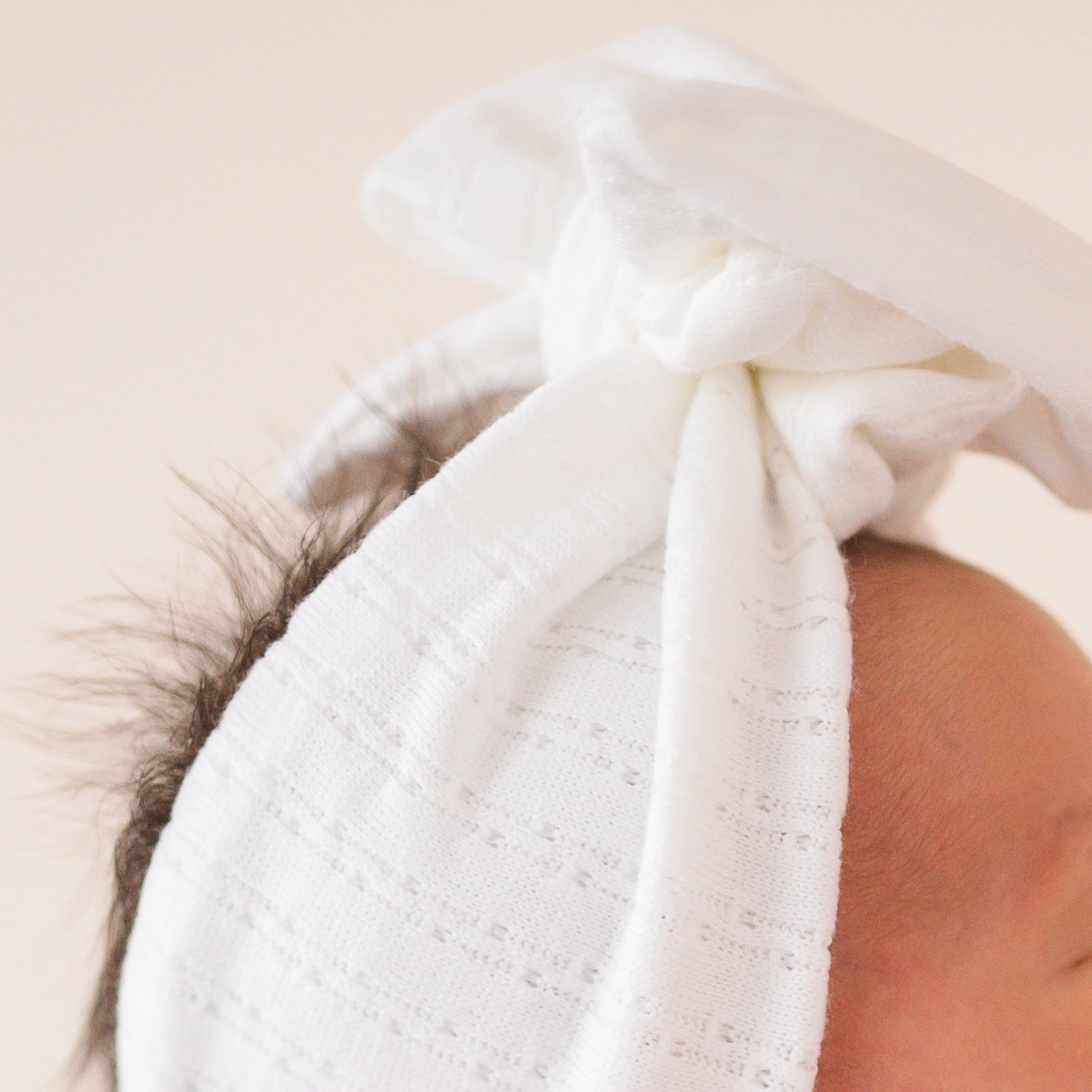 White pointelle fabric baby headband close up texture.