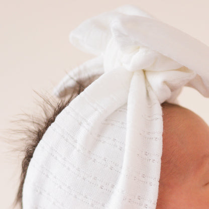 White pointelle fabric baby headband close up texture.