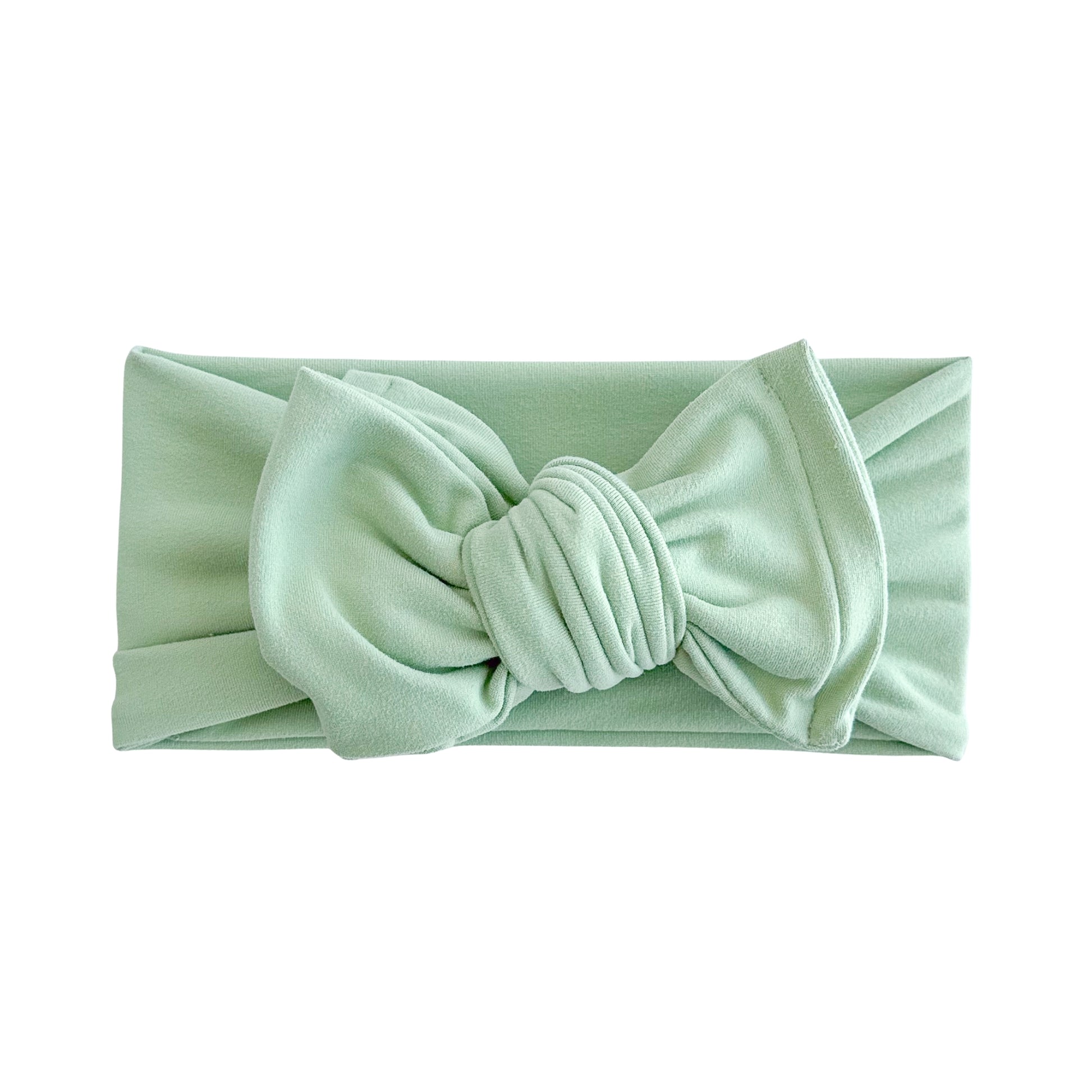 Oversized bow baby headband in keylime green (light bright green), crafted from double brushed knit fabric, displayed on a white background