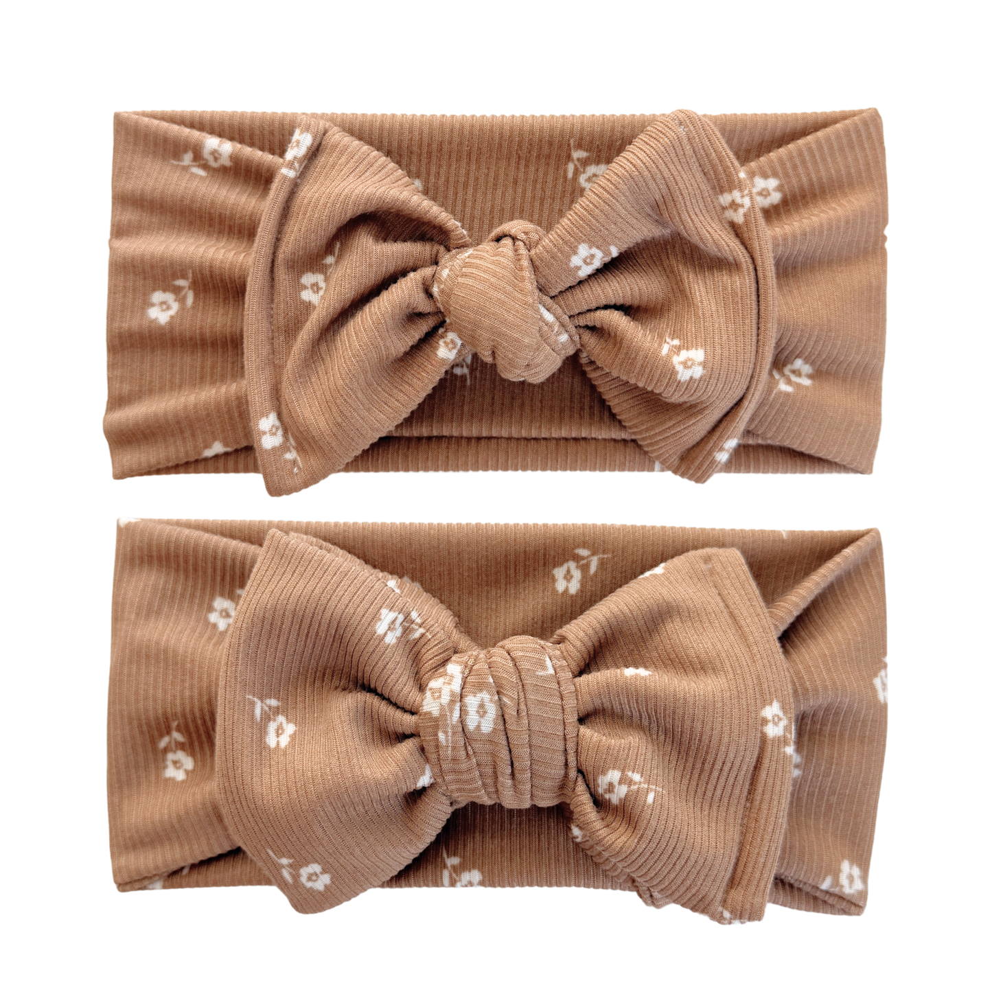 Two brown headbands with large bows and small white floral patterns on a white background