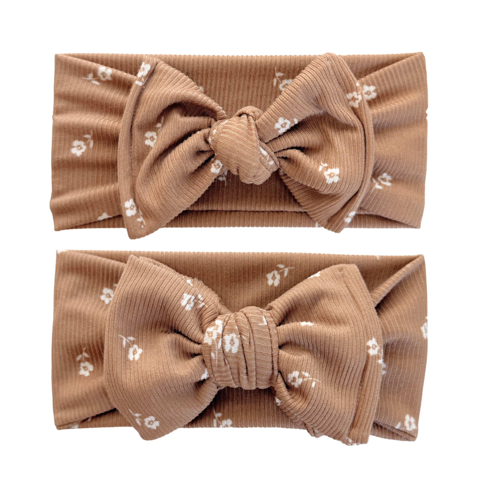 Two brown headbands with large bows and small white floral patterns on a white background