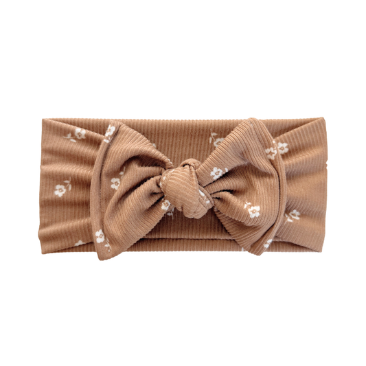 Brown headband with a bow and floral pattern on a white background