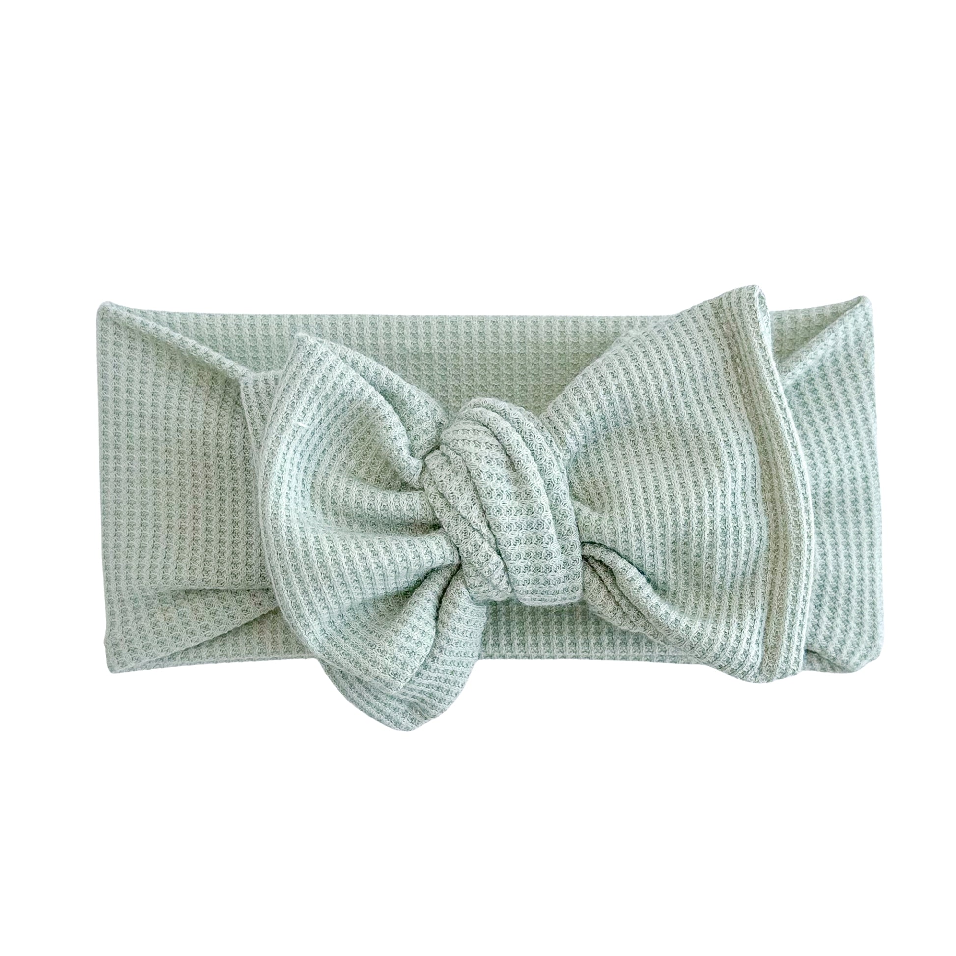 Oversized bow baby headband in light green, crafted from waffle knit fabric, displayed on a white background