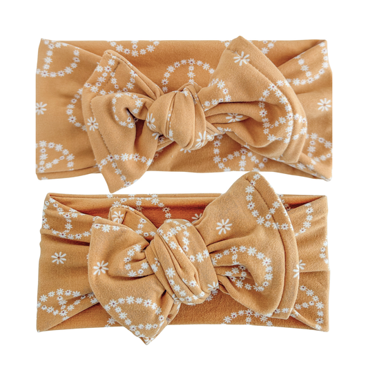 Two yellow headbands with floral patterns on a white background