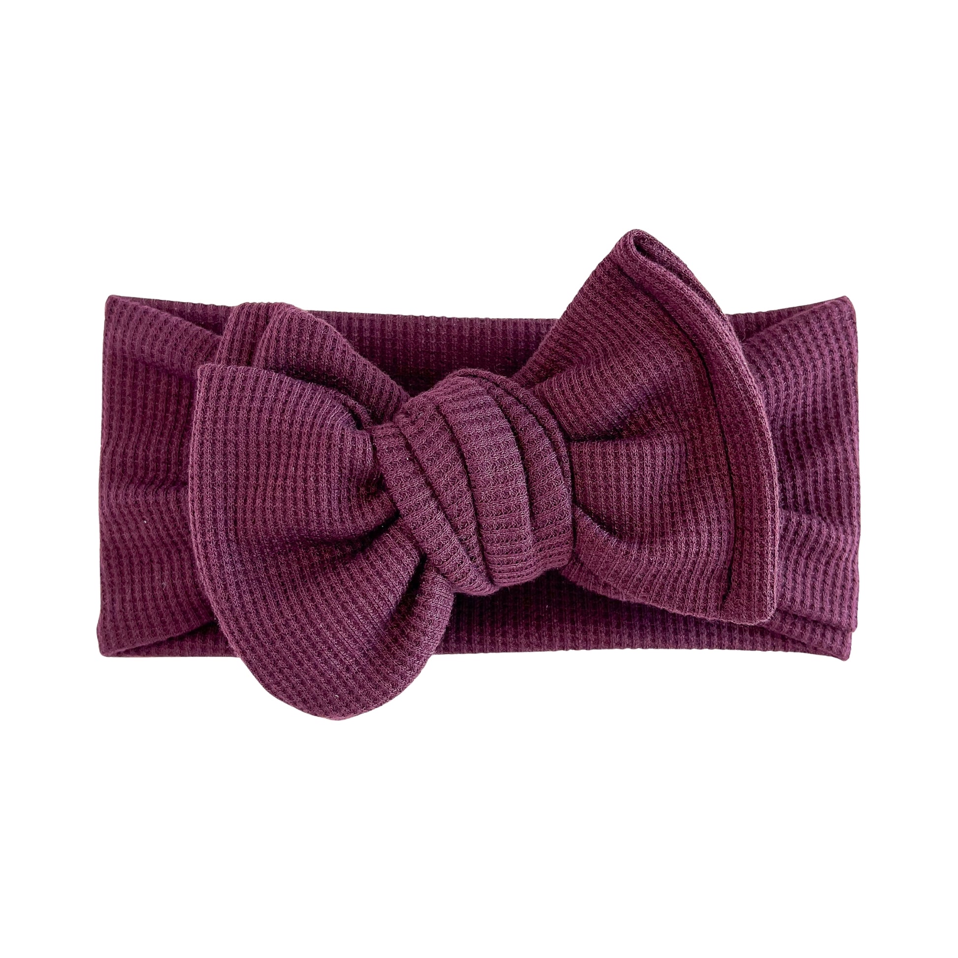 Oversized bow baby headband in maroon (dark purple), crafted from waffle knit fabric, displayed on a white background