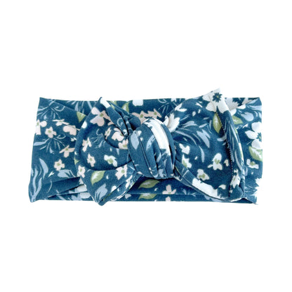 Oversized bow baby headband in navy blue with white large floral print, crafted from double brushed knit fabric, displayed on a white background