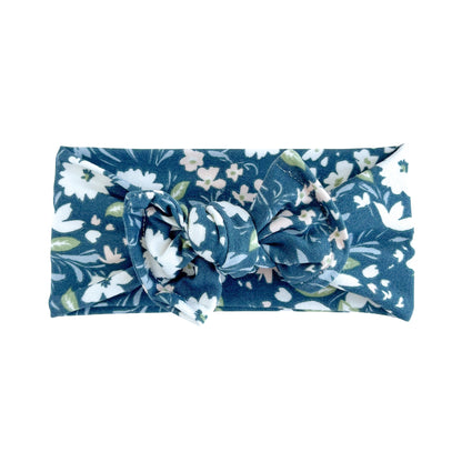 Top knot bow baby headband in navy with white floral print, crafted from double brushed knit fabric, displayed on a white background
