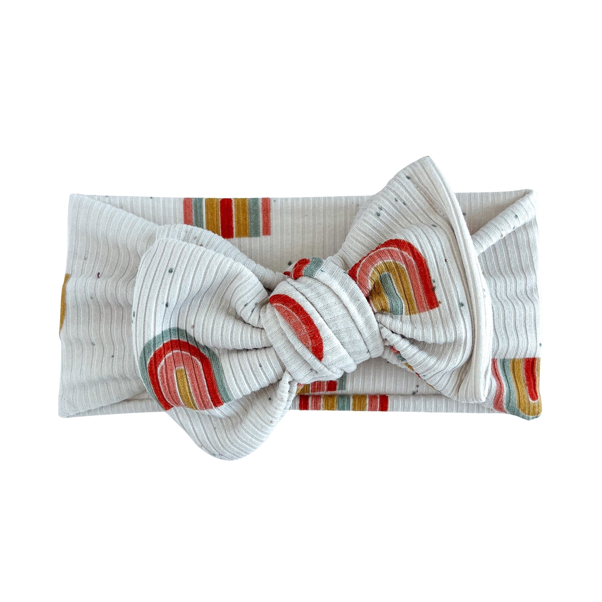 Top knot baby headband in beige with a boho rainbow print, crafted from ribbed knit fabric, displayed on a white background