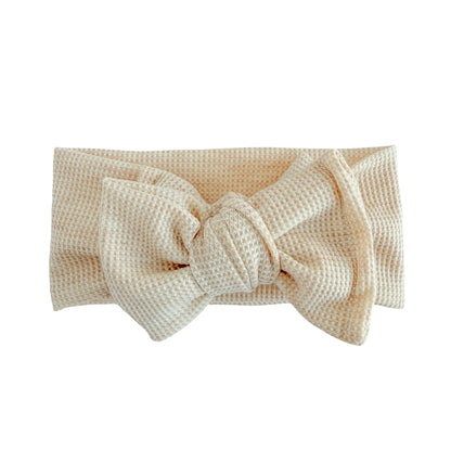 Oversized bow baby headband in oatmeal heather, crafted from waffle knit fabric, displayed on a white background