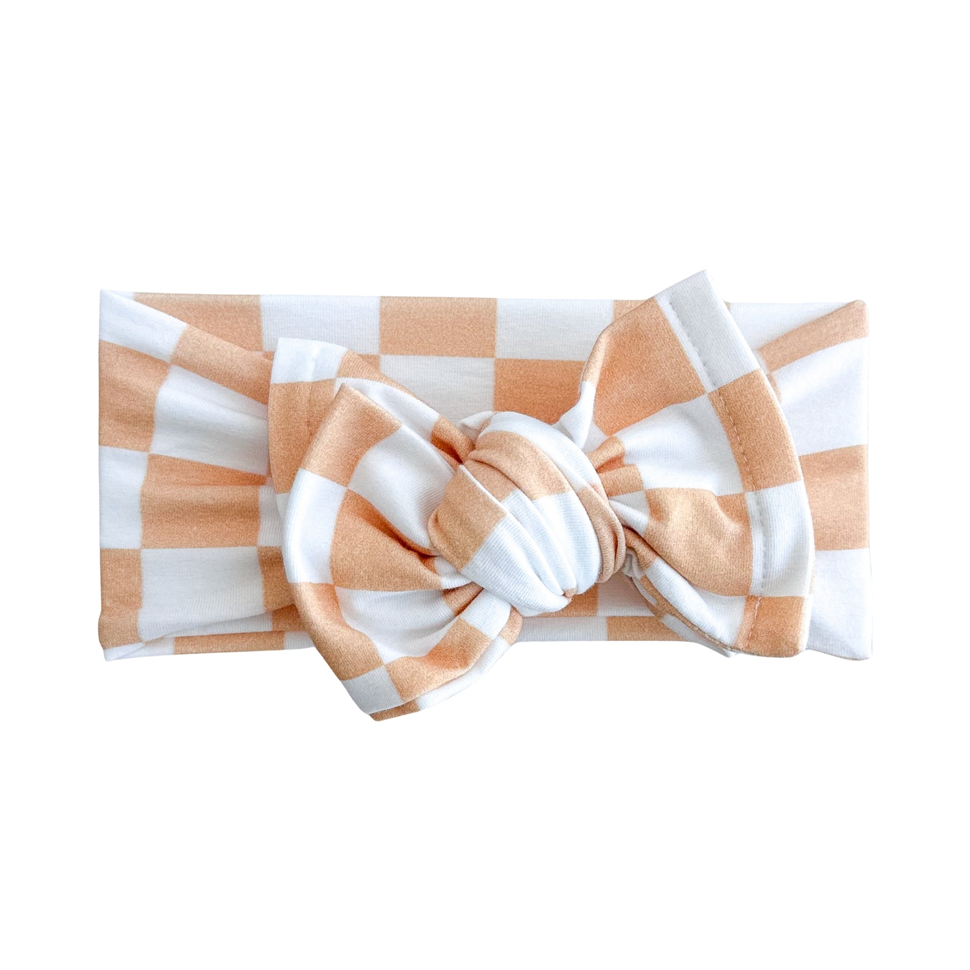 Oversized bow baby headband in orange and white checker print, crafted from cotton jersey knit fabric, displayed on a white background