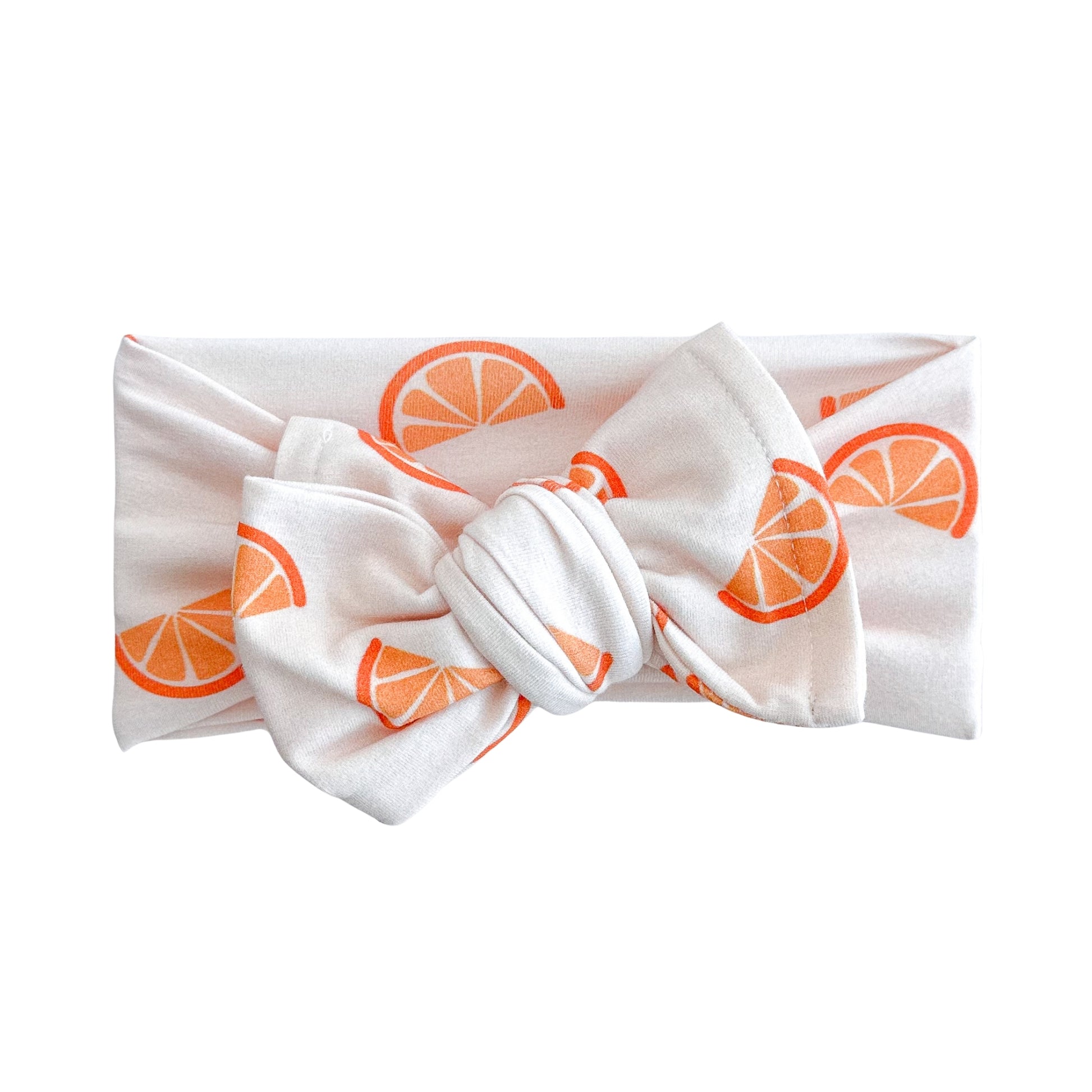 Oversized bow baby headband in orange slices print, crafted from cotton jersey knit fabric, displayed on a white background