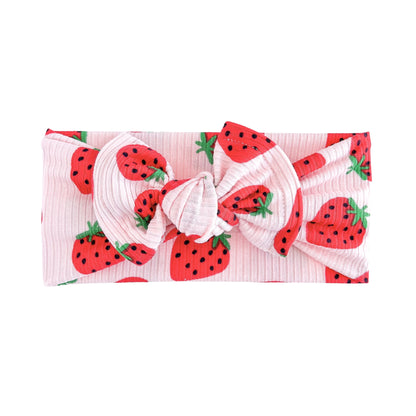 Light pink ribbed headband with strawberry pattern on a white background