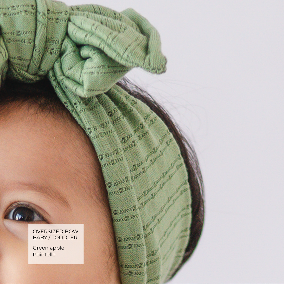 Detail view of apple green pointelle knit oversized bow.