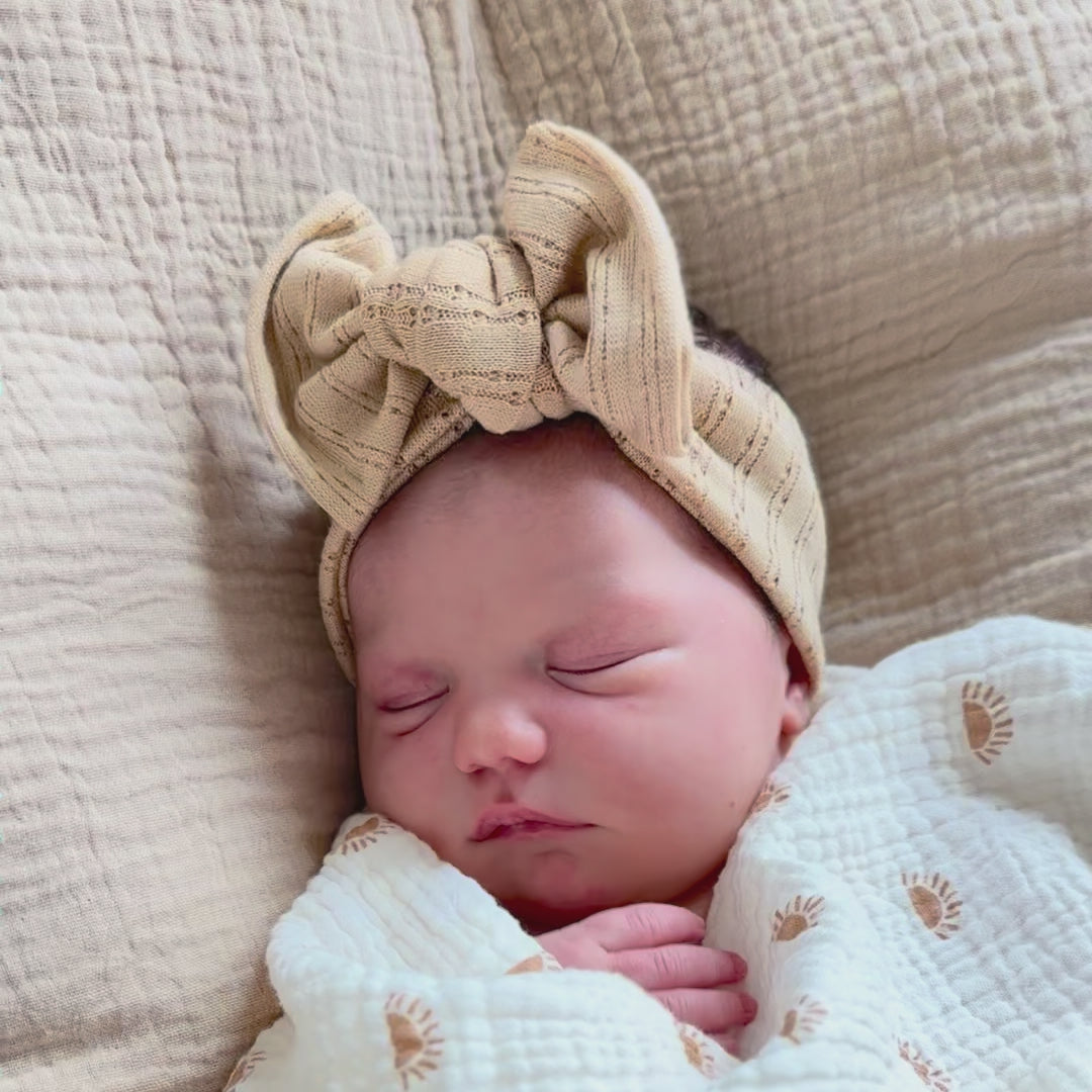 Baby sleeping caramel pointelle top knot bow.