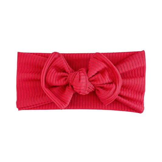 Red ribbed top knot headband with a large bow on a white background